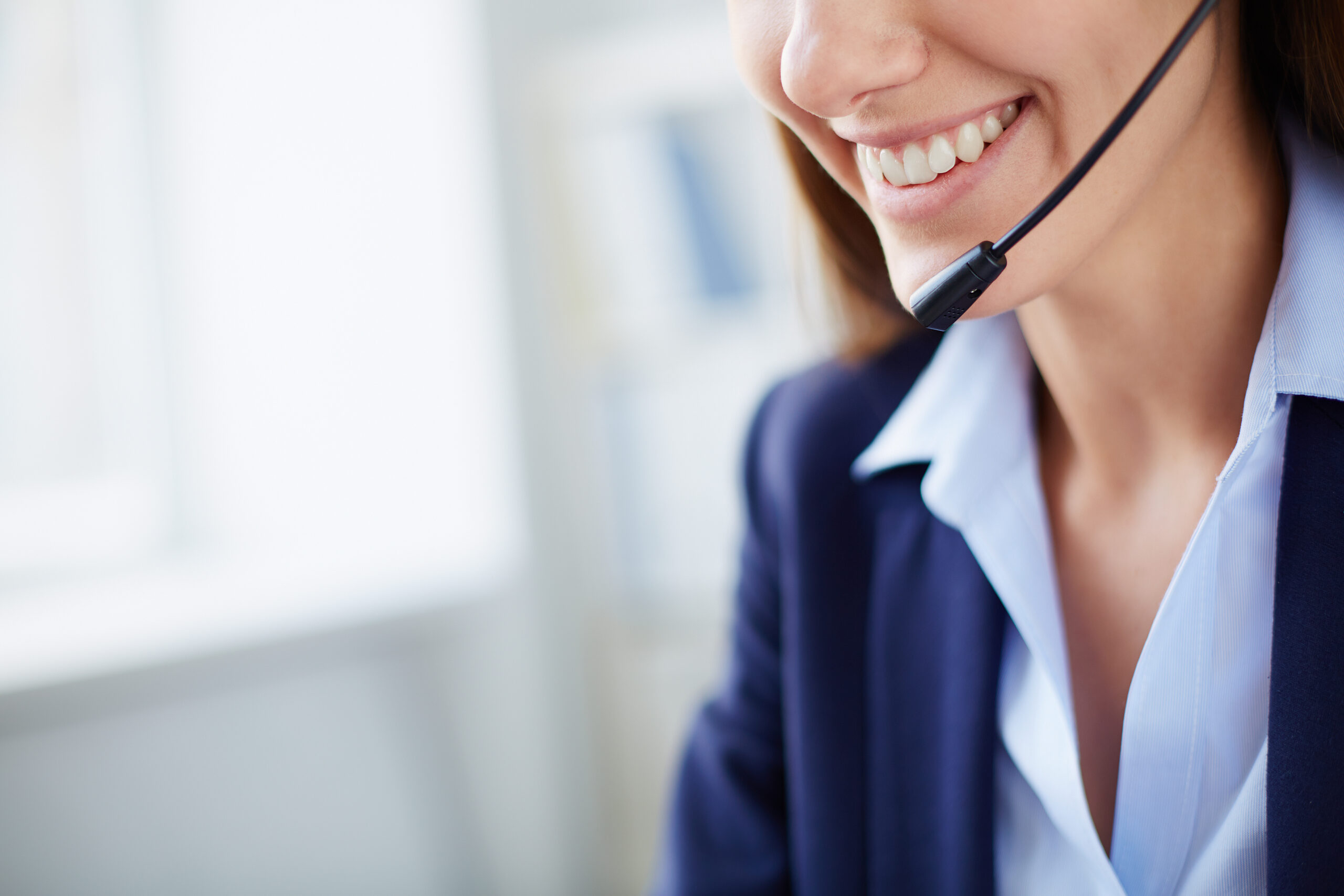 Toothy smile of young businesswoman with headset